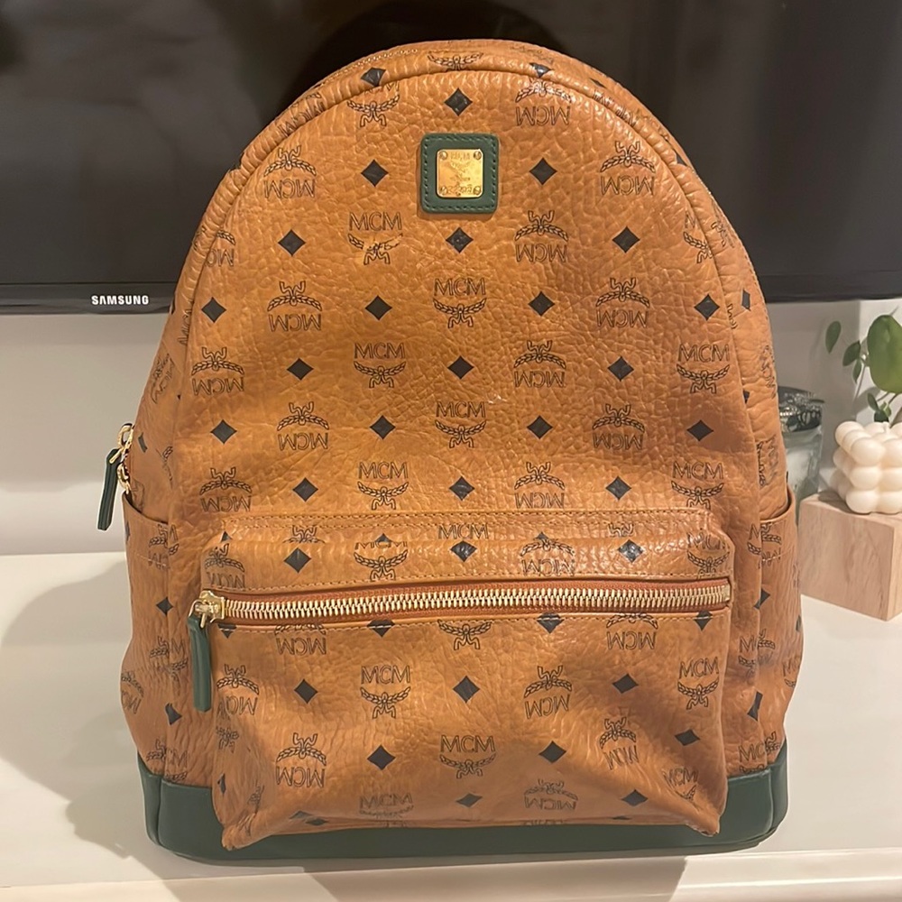 MCM large back pack with dark forest green and gold details.